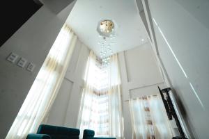 a room with a large window and a chandelier at Zensole Resort in Tarlac