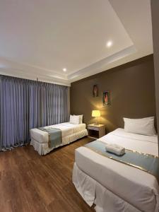 a hotel room with two beds and a window at Villa Verde Guest House in General Santos
