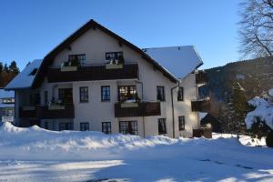 een groot wit gebouw met sneeuw ervoor bij Hoffmann's Apartment in der Residenz Bocksbergblick in Hahnenklee-Bockswiese
