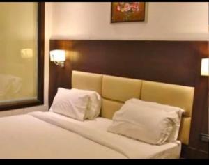 a bedroom with a bed with white pillows at Hotel namo in Alwar