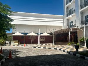 a building with white umbrellas in front of it at Utc Damhil By Prasanthi in Telaga