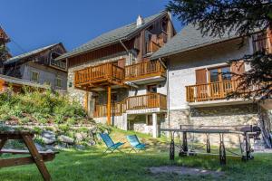 a house with two chairs and a table in the yard at Chalet Dibona in Vaujany