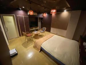 a bedroom with a bed and a table and chairs at ホテル大東京 男塾ホテルグループ Adult Only in Takamatsu