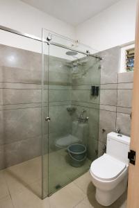 a bathroom with a glass shower with a toilet at Maple grove villa resort in Panamaram +35 photos