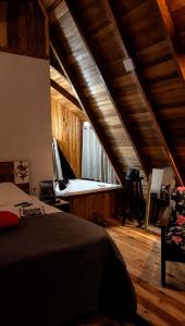 a bedroom with a bed and a tub in the attic at Pé na Picada in Urubici