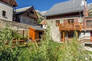 a stone house with a balcony in a village at Chalet Lucette - bijoux style 200m from the piste in Vaujany