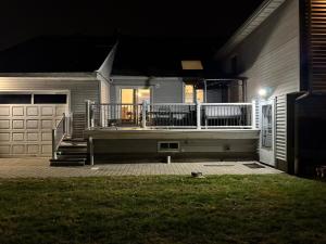 a house with a porch and a deck at night at Studio - NYC, Greenwich, Capitol, Parking in Port Chester