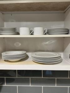 a shelf with plates and cups and dishes on it at Studio - NYC, Greenwich, Capitol, Parking in Port Chester +19 photos