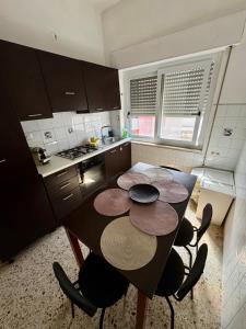 a kitchen with a table and some chairs in it at Penthouse Panoramic in Pantelleria