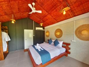 a bedroom with a bed with a ceiling at Cow Barn Cafe and Lodge Preah Vihear in Phumĭ Nhông