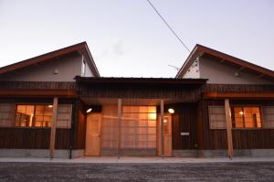 Shinkamigotoにある五島バックパッカーズ ぽれの木製のドアと窓のある建物