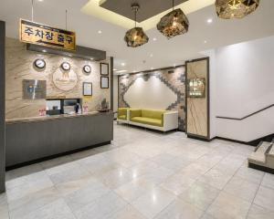 a lobby of a restaurant with a yellow couch at Hotel Midas in Daegu