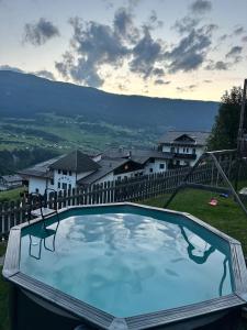 a large swimming pool in a yard with houses at Apart Neunerhof in Jerzens