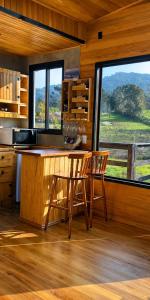 a kitchen with a table and two chairs and a window at Pé na Picada in Urubici