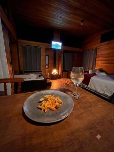 a plate of pasta and a glass of wine on a table at Pé na Picada in Urubici
