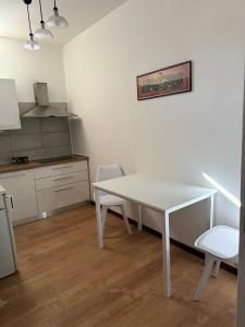 a kitchen with a white table and chairs in a room at Ai Melograni Apartment in Silea