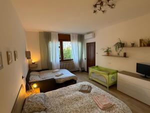 a small room with two beds and a television at Ai Melograni Apartment in Silea