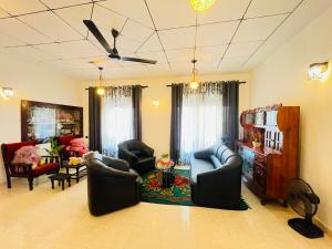 a living room with couches and chairs and a ceiling at Villa Dinusara in Weligama