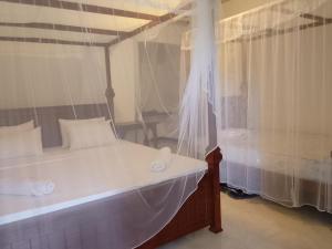 a bedroom with a white bed and a window at Wilpattu Coconut Villa in Nochchiyagama +22 photos