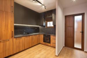 a kitchen with wooden cabinets and a ceiling fan at Villa President 2 in Kunjići