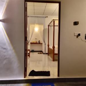 a hallway with a mirror and a room with a bed at Wilpattu Coconut Villa in Nochchiyagama