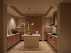 a kitchen with a counter with a vase of flowers on it at is.land Villa in Sanya