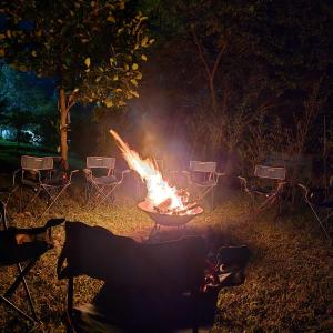 a fire in a grill in a yard at night at Bwindi Neckview Lodge in Buhoma