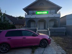 a pink car parked in front of a house at melvina LUX in Pančevo