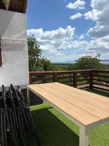 a wooden table and chairs on a balcony at Mona-Lak Balaton Panorama in Zánka