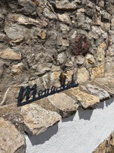a sign on the side of a stone wall at Mona-Lak Balaton Panorama in Zánka