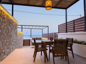a dining room with a table and chairs on a balcony at Marizon Suites - Adults Only in Vrachonisída touArchangélou