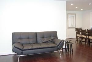 a leather couch in a living room with tables and chairs at Silicon Valley Stays Casa Uno in Mountain View