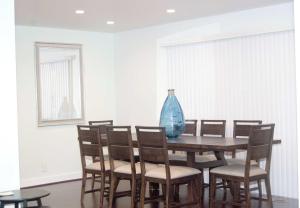 a vase sitting on a wooden table with chairs at Silicon Valley Stays Casa Uno in Mountain View