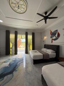 a bedroom with two beds and a ceiling fan at Bunohan Villa Homestay in Tumpat