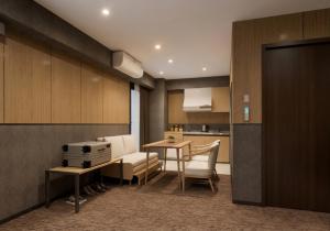 a living room with a table and a kitchen at KABIN Shiro - Regale Collection in Osaka