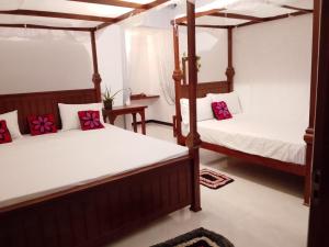 a bedroom with two bunk beds and a table at Wilpattu Coconut Villa in Nochchiyagama
