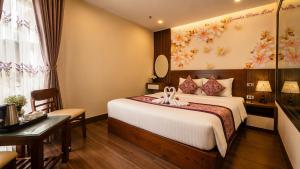 a hotel room with a bed and a desk at Lavender SaPa Hotell & Spa - Free foot soak service in Sapa