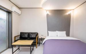 a small room with a bed and a chair at Hotel Midas in Daegu