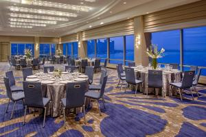 a banquet hall with tables and chairs andwindows at Hyatt Regency Jersey City on the Hudson in Jersey City