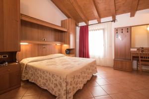 1 dormitorio con cama, mesa y ventana en Agriturismo Da Merlo, en Trivignano