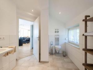 a white bathroom with a toilet and a sink at Ferienwohnung Rohrhofer in Tiefenbach +9 photos