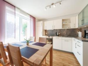 a kitchen with white cabinets and a wooden table at Ferienwohnung Rohrhofer in Tiefenbach