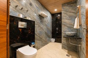 a bathroom with a toilet and a black marble wall at Hotel Dev Vilas 600 Metres from Taj Mahal in Agra +56 photos