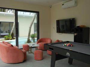 a living room with a pool table and chairs at 86 Villa in Mui Ne