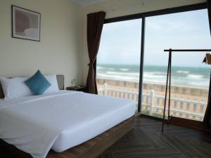 a bedroom with a bed and a view of the ocean at 86 Villa in Mui Ne +69 photos