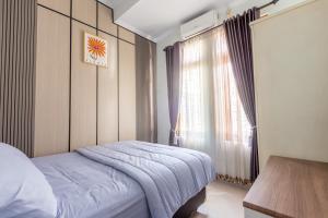 a bedroom with a bed and a window at Homestay Rumahnya Diaz in Kejayan