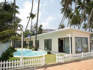 a house with a pool and palm trees at 86 Villa in Mui Ne