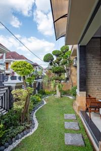 a small garden with grass and trees on a house at Homestay Rumahnya Diaz in Kejayan