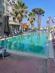 a large swimming pool with chairs and palm trees at Fiona's Sea View Apartment in Golem