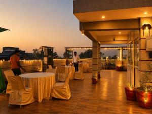 a patio with white tables and chairs on a roof at Hotel Dev Vilas 600 Metres from Taj Mahal in Agra